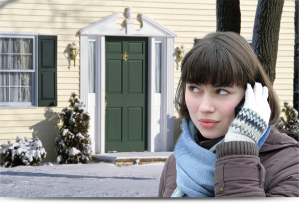 A woman talking over phone near a house